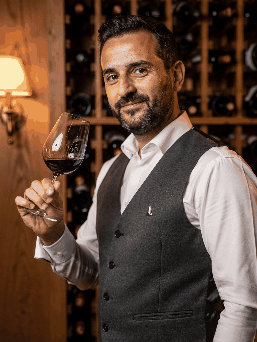 Sommelier Marco Moretti selecting a vintage bottle in the cellar
